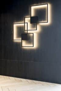 Een zwart wand met decoratieve verlichtingsarmaturen. De wand is afwerkt in zwart plaatmateriaal met een levendige houtstructuur, de U129 Sherwood van Cleaf