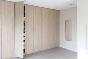 Kastenwand in decoratief plaatmateriaal S164 Fronda van Cleaf, welke de structuur van gebeitst iepenhout heeft, met open deur