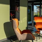 Zithoek met kast in UB54 Ovatta en S171 Bruciato met oranje stoelen