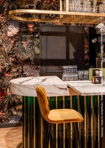 Restaurant met een verfijnde mamerlook op op de bar uitgewerkt met decoratief plaatmateriaal FB38 Talco van Cleaf, welke een uitstraling van Carrara marmer in wit met donkergrijze aders heeft.