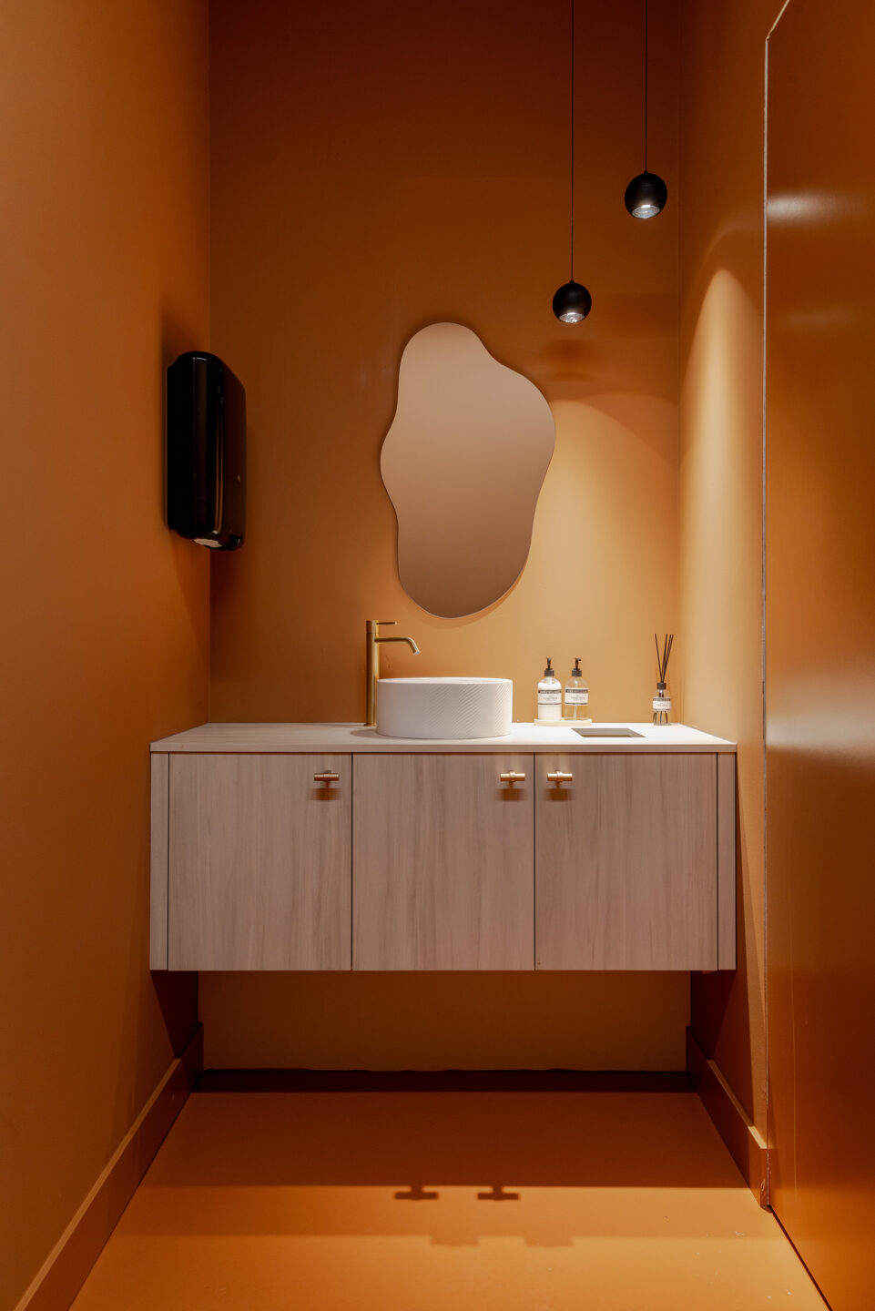 Wastafel in toilet in licht hout LS63 Ceppo met oranje wanden, organische spiegel en