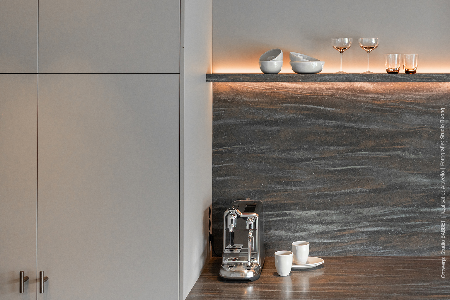 Keuken met kookeiland in warmbruin solid surface DM5004 Volcano met steenrode en grijze nuances, taupekleurige kasten in UA94 Talco en wandafwerking in Pallisanderdecor LK00 Matrix met voelbare houtnerf