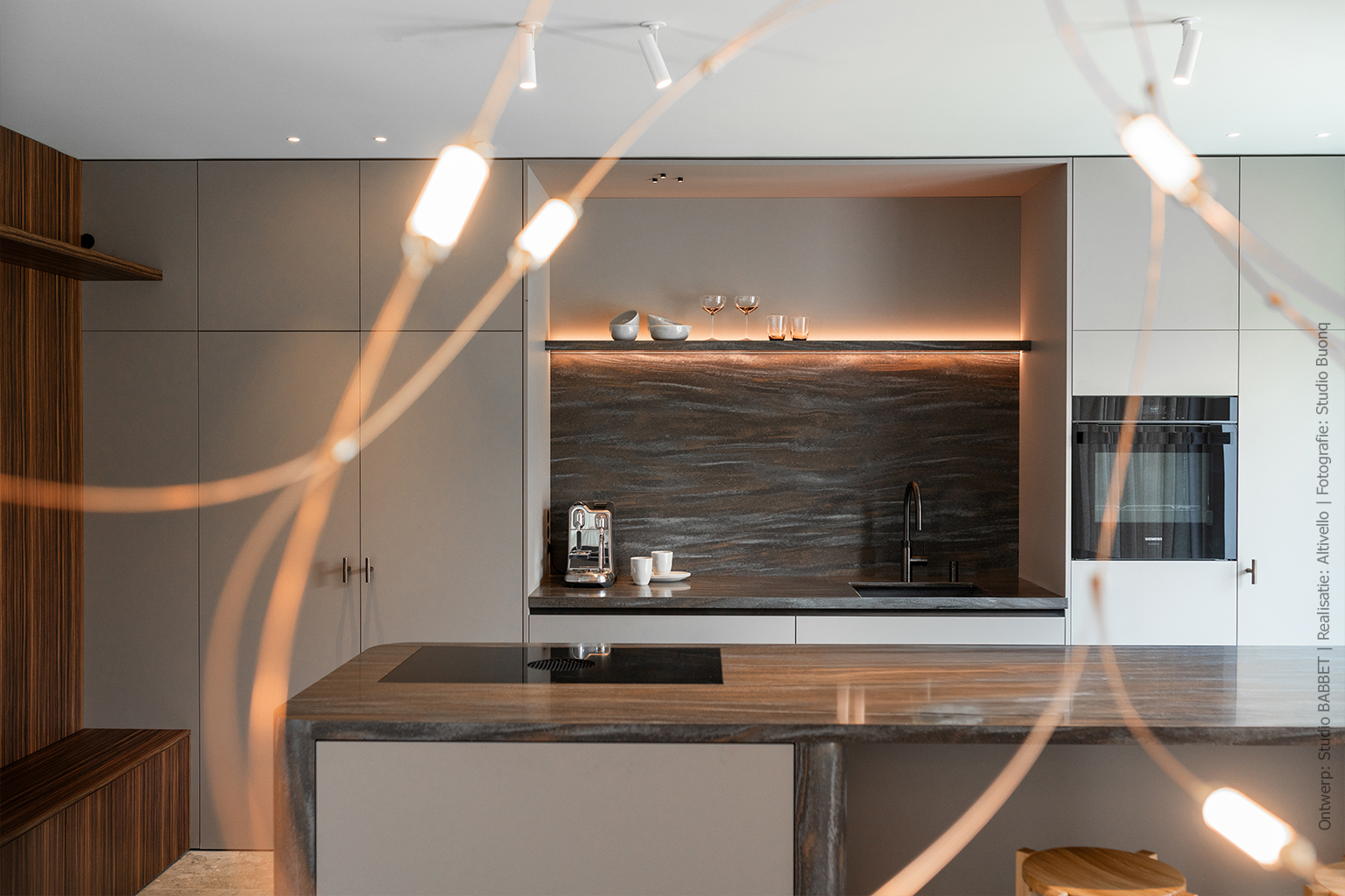 Keuken met kookeiland in warmbruin solid surface DM5004 Volcano met steenrode en grijze nuances, taupekleurige kasten in UA94 Talco en wandafwerking in Pallisanderdecor LK00 Matrix met voelbare houtnerf