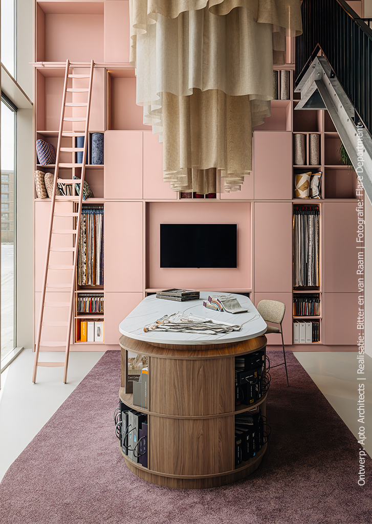 Stijlvolle showroomopstelling met vakkenkast in poederroze UB52 Ovatta, gecombineerd met een walnoot werktafel in LS40 Poro Noce en een Durasein werkblad met marmerlook.